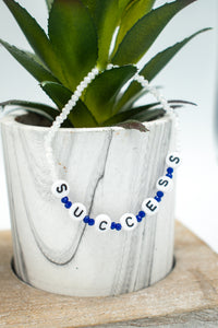 powerful words bracelet lying on plant