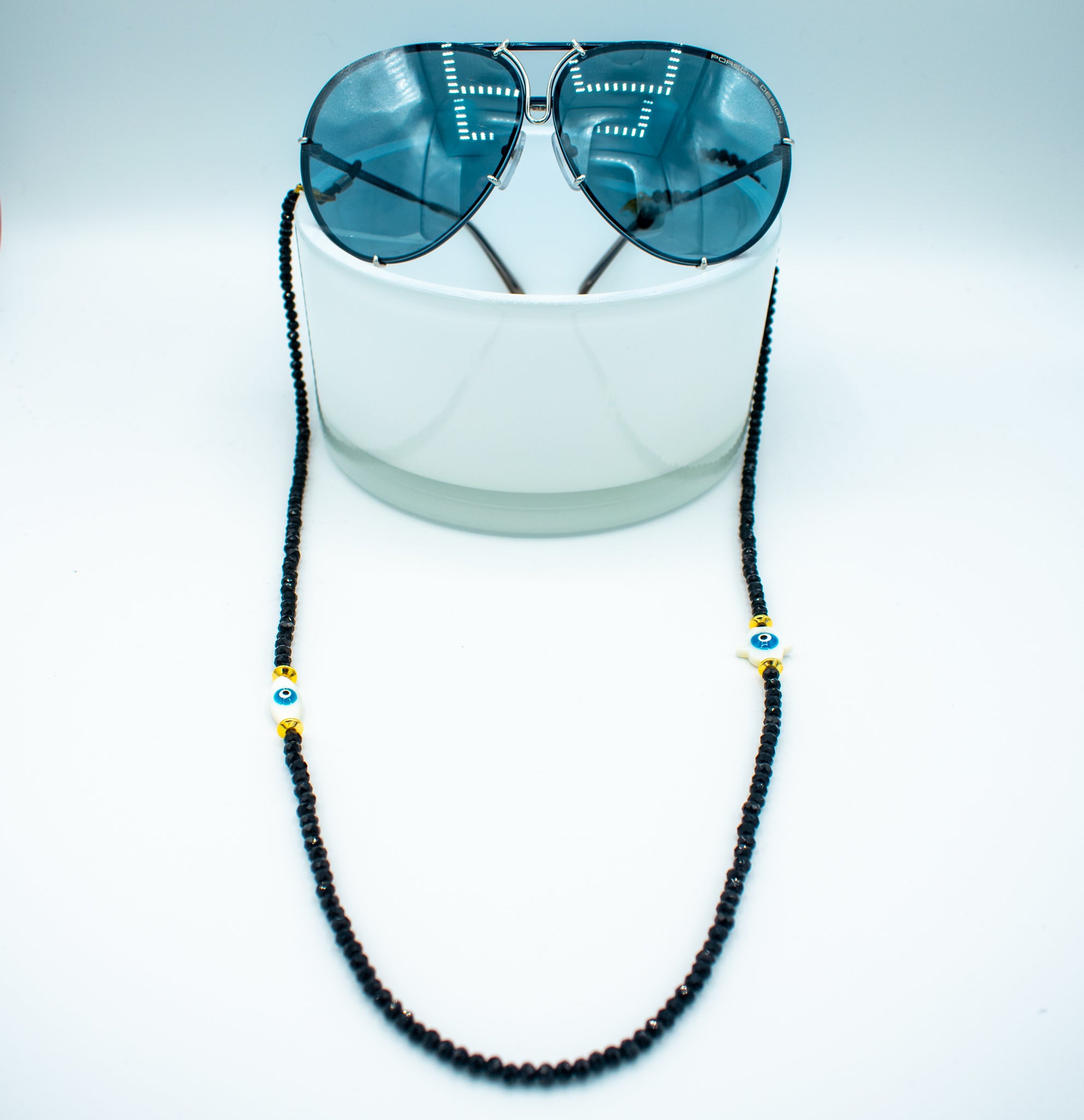 3 in 1 long beaded string black beads and evil eye bead with golden accent hooked on sunglasses