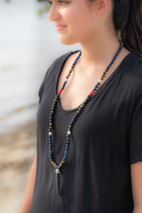 side view of a girl wearing Healing stones with long pendant necklace