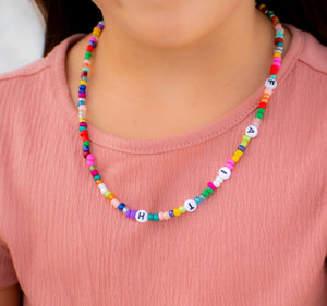 young girl wearing a words necklace 