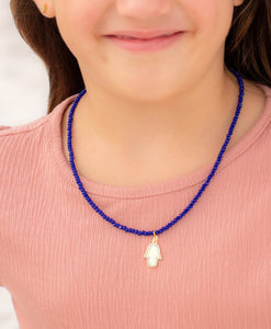 woman wearing royal blue hamsa necklace