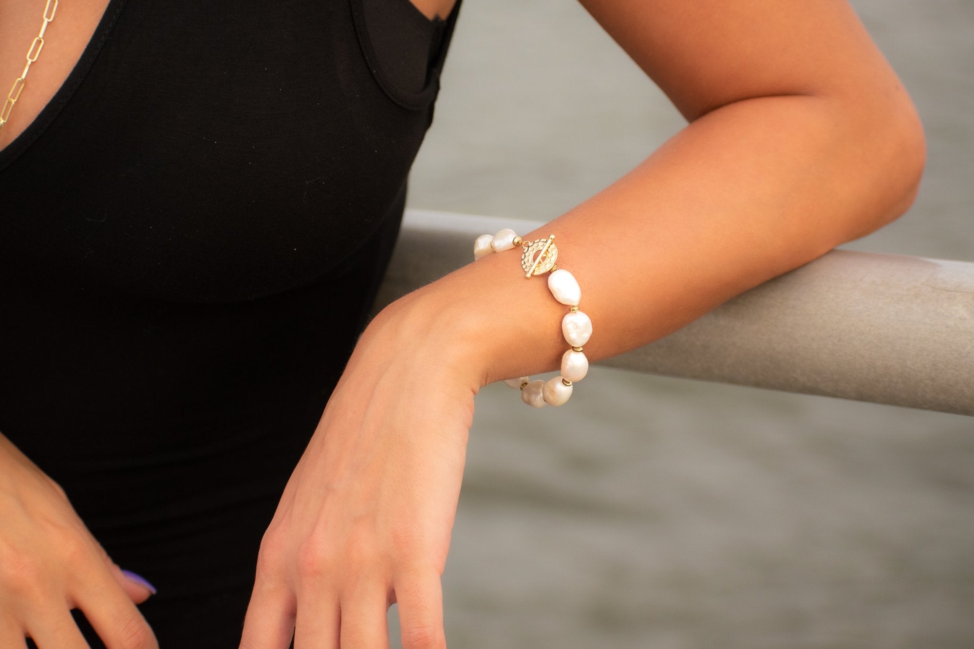 woman wearing a Pearl bracelet with golden thick clasp